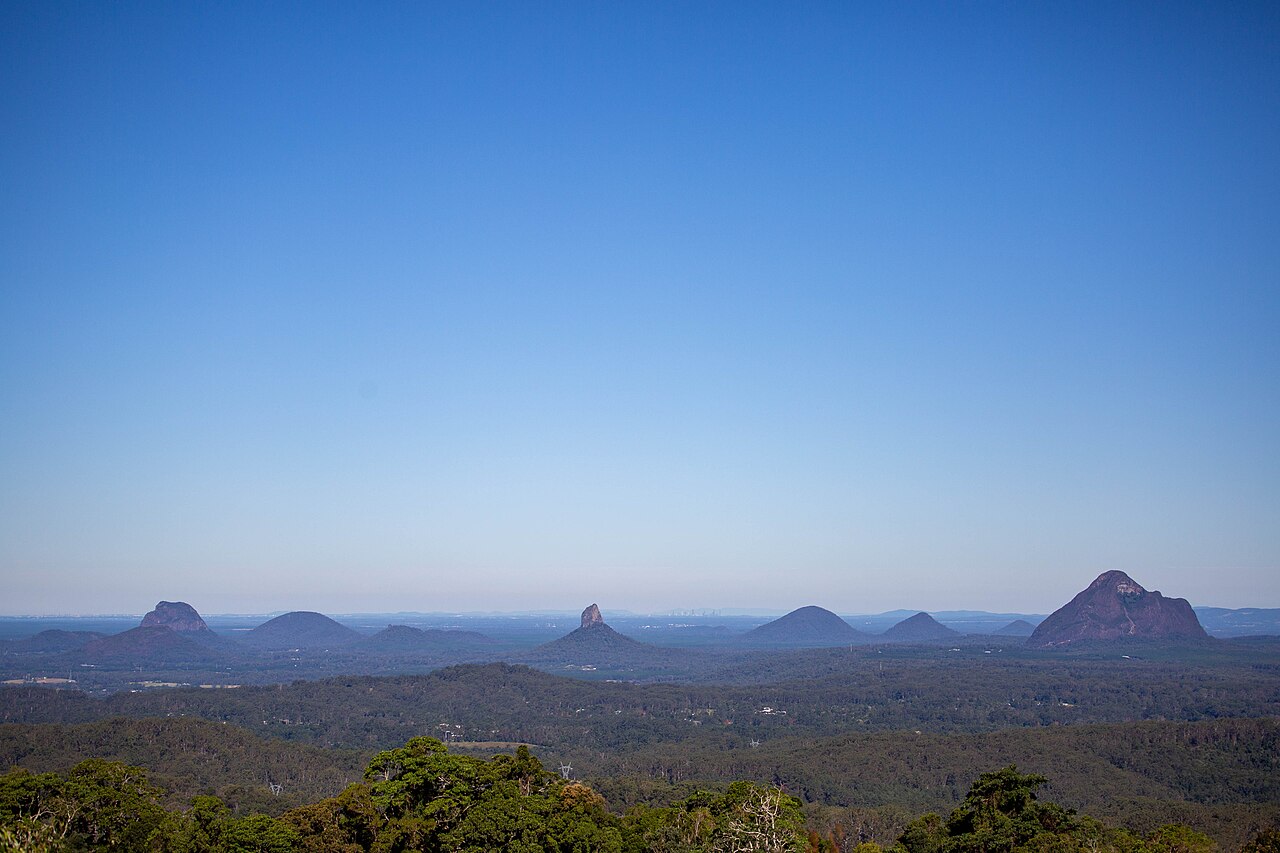 Dramatic peaks of the Glass House Mountains rising from green hinterland